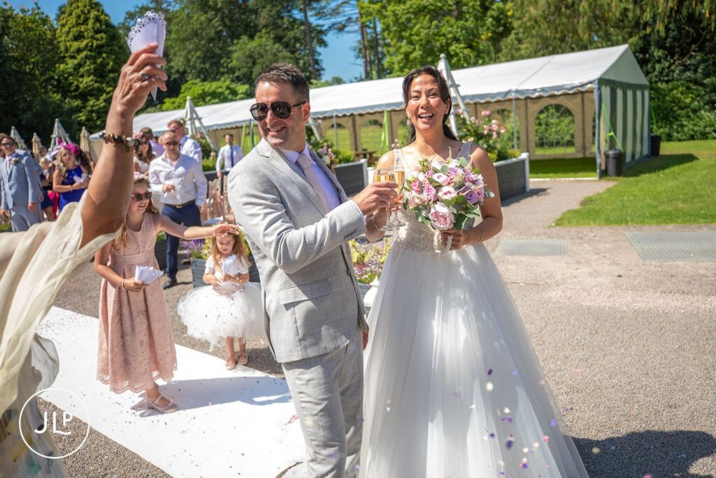 Confetti moment for Mel and Ben at their outdoor wedding at De Vere Tortworth Court.