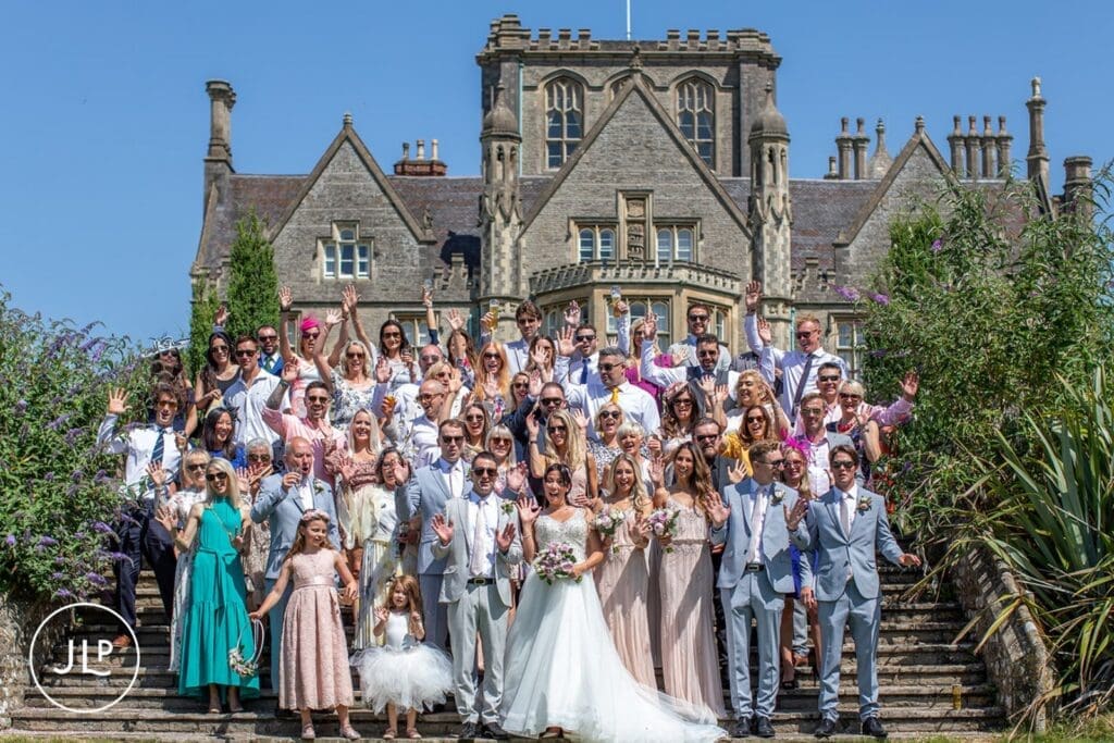 Massive wedding guest group shot on the steps by a professional Tortworth wedding photographer.