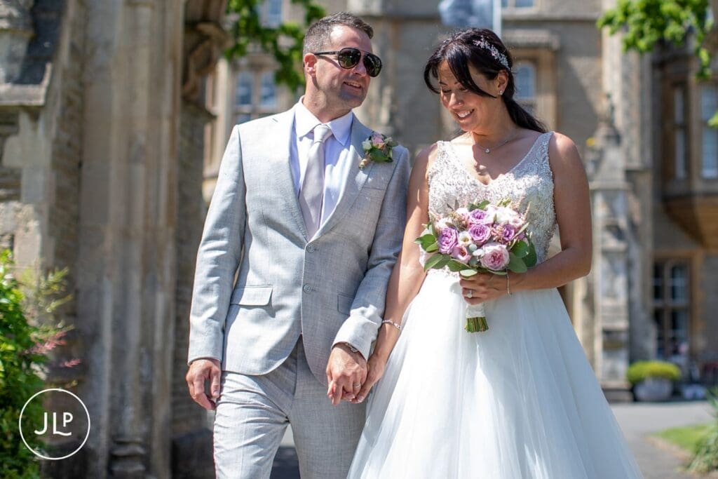 Newlyweds walking hand-in-hand outside captured by a candid wedding photographer UK.