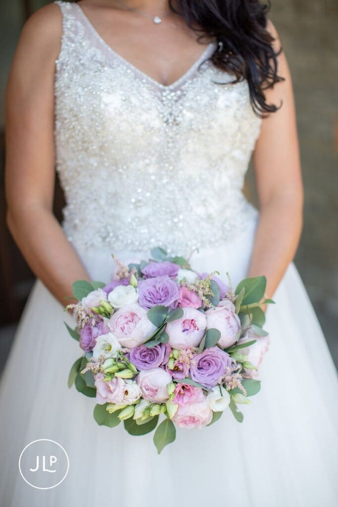 Full-length portrait of a beautiful bride holding her bouquet at a luxury Gloucestershire wedding venue.