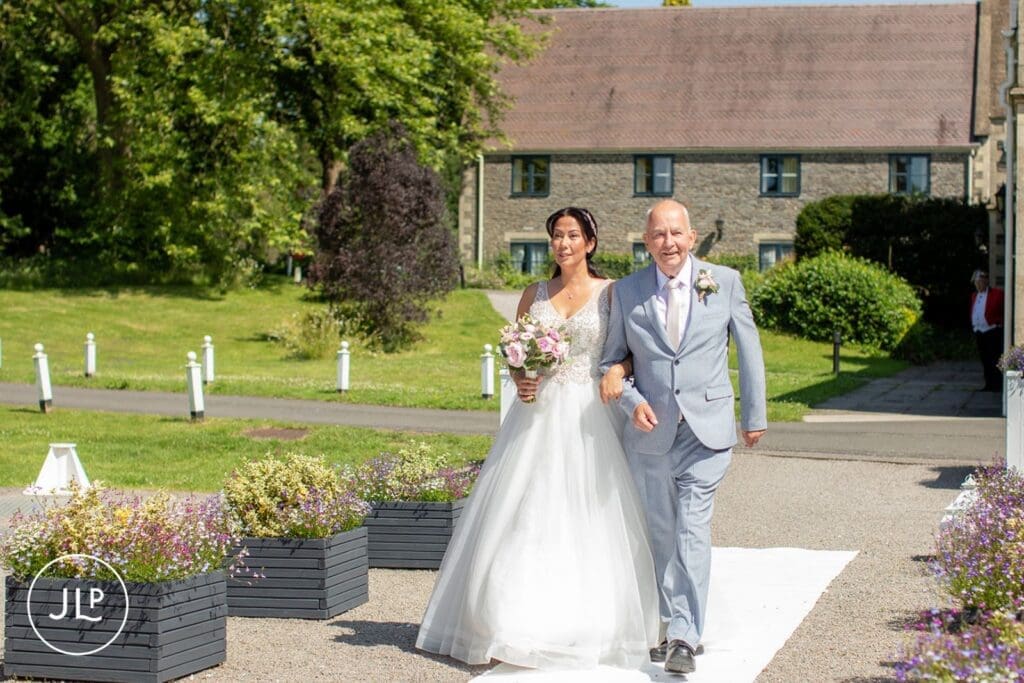 Bride walking down the aisle with her father at a luxury Gloucestershire wedding venue.
