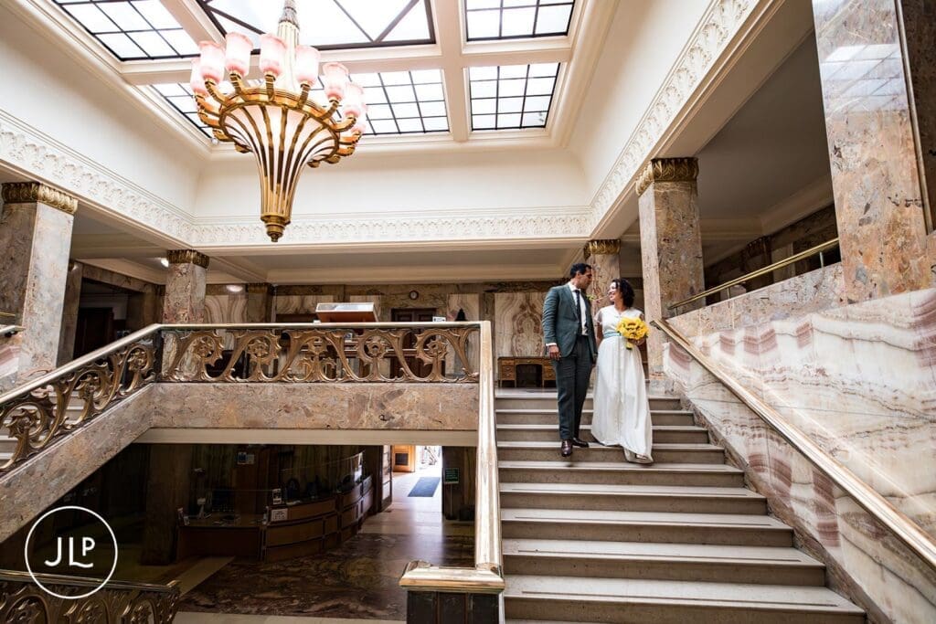 Elegant London wedding photography of a couple walking down the grand stairs at Wandsworth Town Hall.