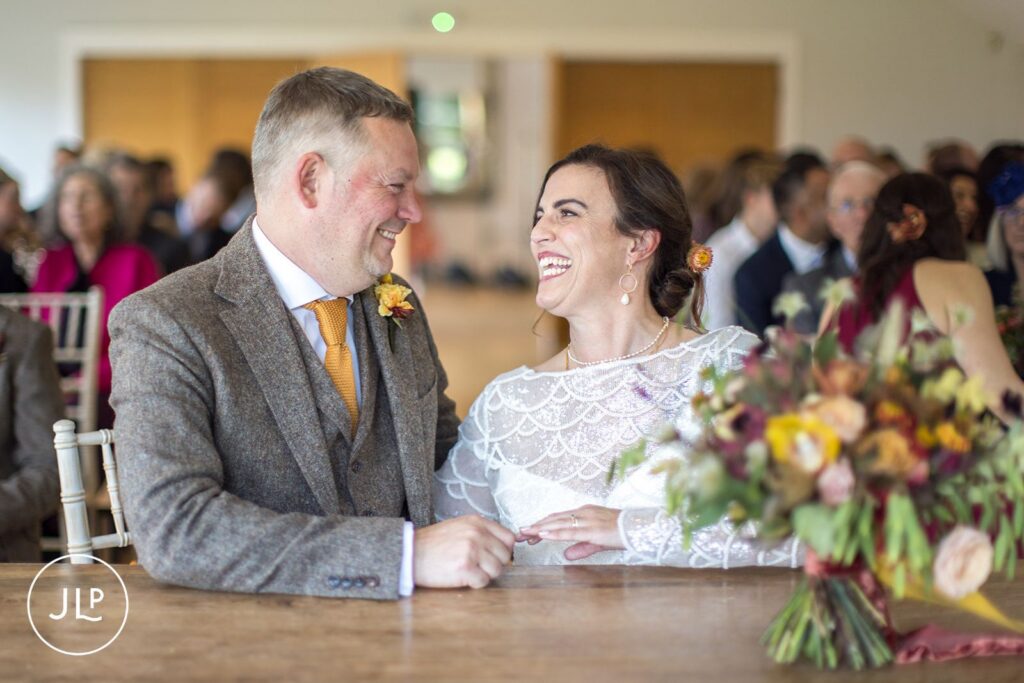 A couple signing their wedding register during a relaxed autumn wedding at Wasing Park Berkshire.