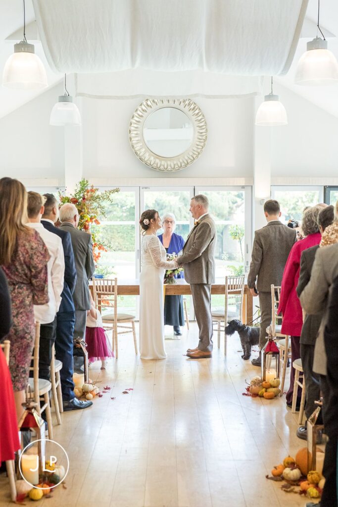 Natural wedding photography of a couple holding hands during an autumn ceremony at Wasing Park venue.