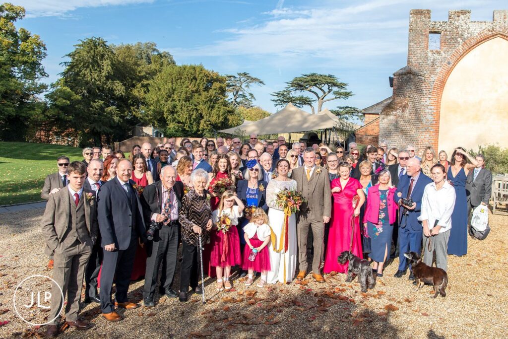 Berkshire wedding photographer capturing a full group shot of wedding guests on a sunny autumn day.