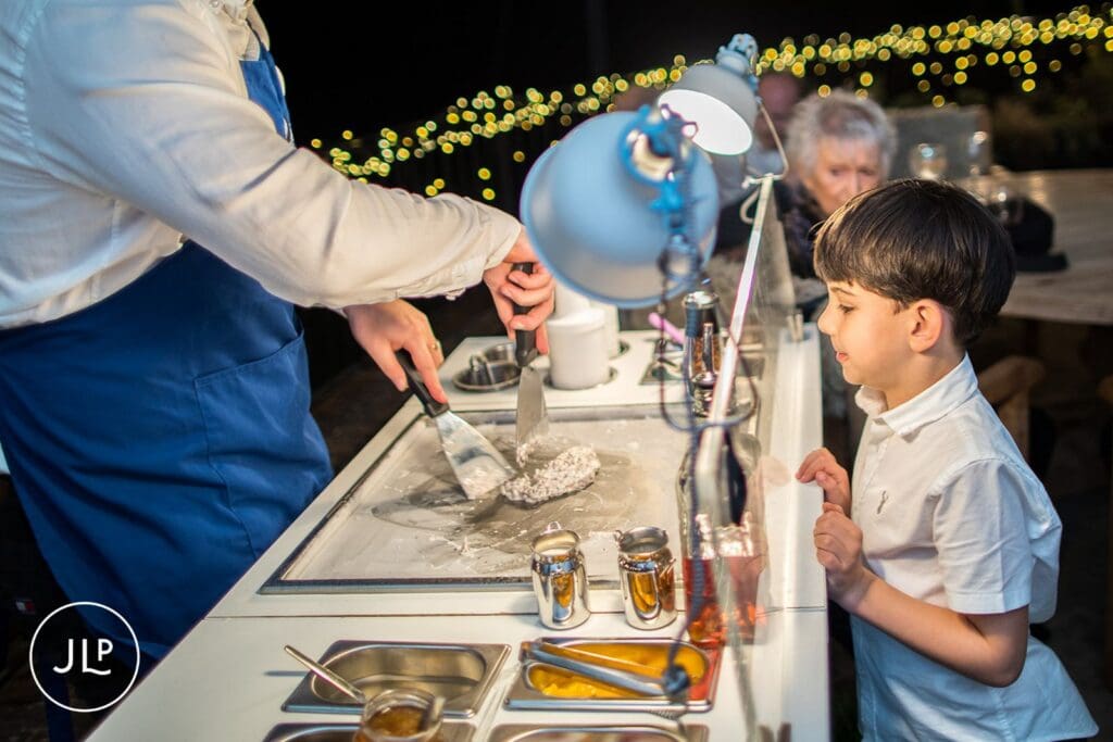 A young boy watching an ice cream station vendor at a relaxed autumn wedding at Wasing Park Berkshire.
