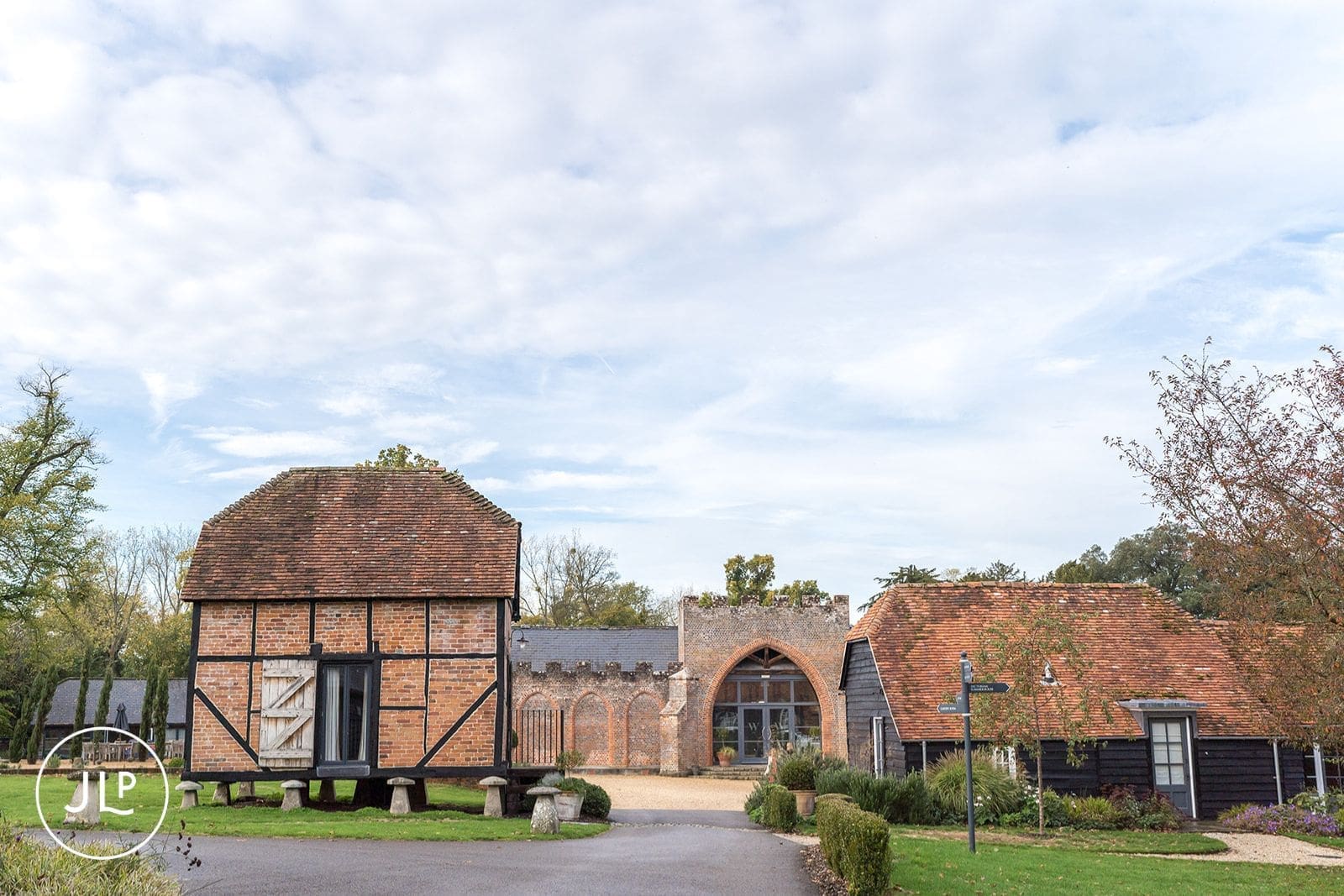 Rustic property at Wasing Park wedding venue in the Berkshire countryside under a cloudy autumn sky.