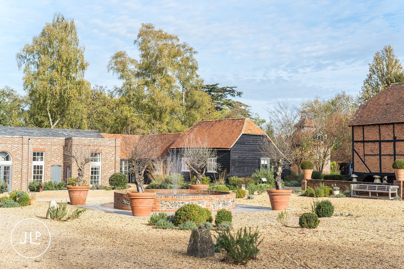 A scenic courtyard fountain surrounded by gravel and brick buildings at a Berkshire wedding venue.