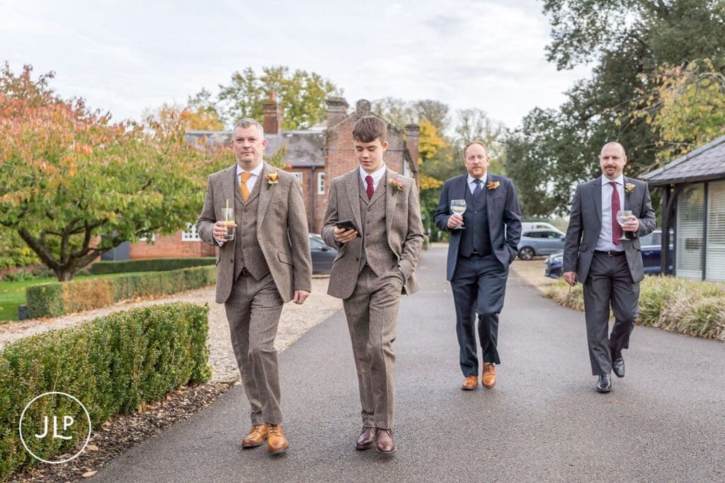 Groom and groomsmen walking outside the Wasing Park wedding venue during a relaxed autumn wedding.