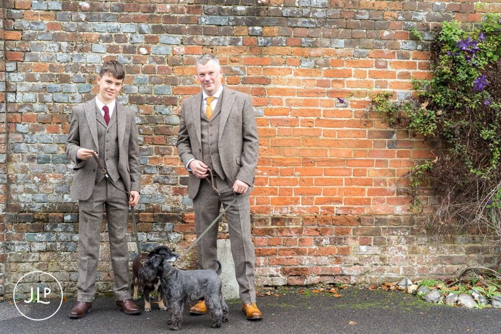 Candid wedding photography of the groom and his son with their dogs at Wasing Park in Berkshire.