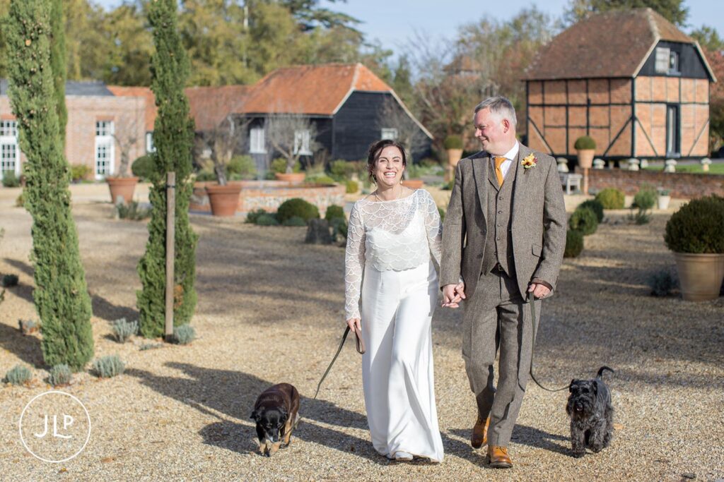 Wasing Park wedding photographer captures a happy couple walking their two dogs across the gravel pathways.