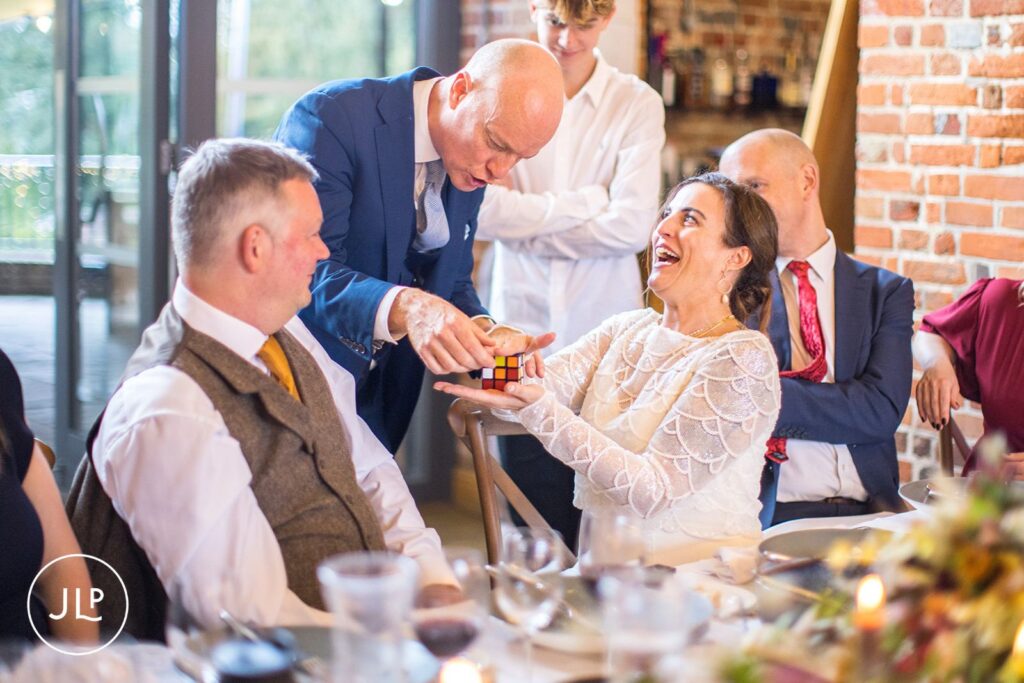 Bride laughing at a Rubik's cube trick, showcasing fun wedding photography at Wasing Park Berkshire.