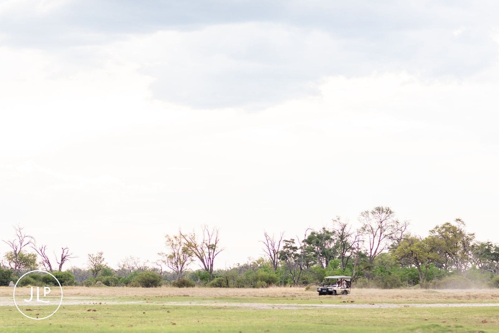 Safari vehicle drives across the plains for a destination wedding Botswana.