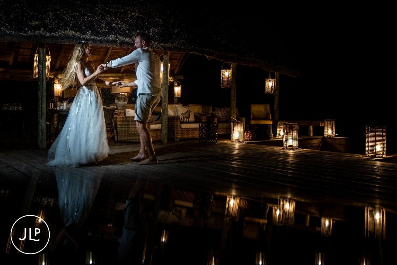 Bride and groom dance on a lantern-lit deck at night, captured by an Okavango Delta wedding photographer.