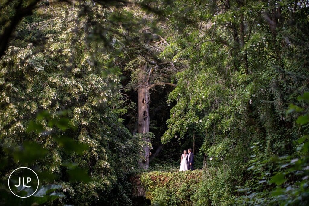 Bride and groom standing on a bridge, showcasing a luxury Surrey wedding hidden in nature.