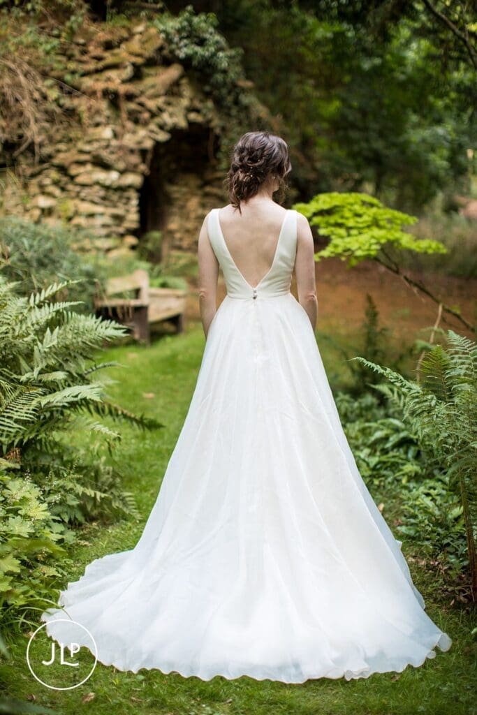Back of a bride's stunning white wedding gown during a luxury marquee wedding.