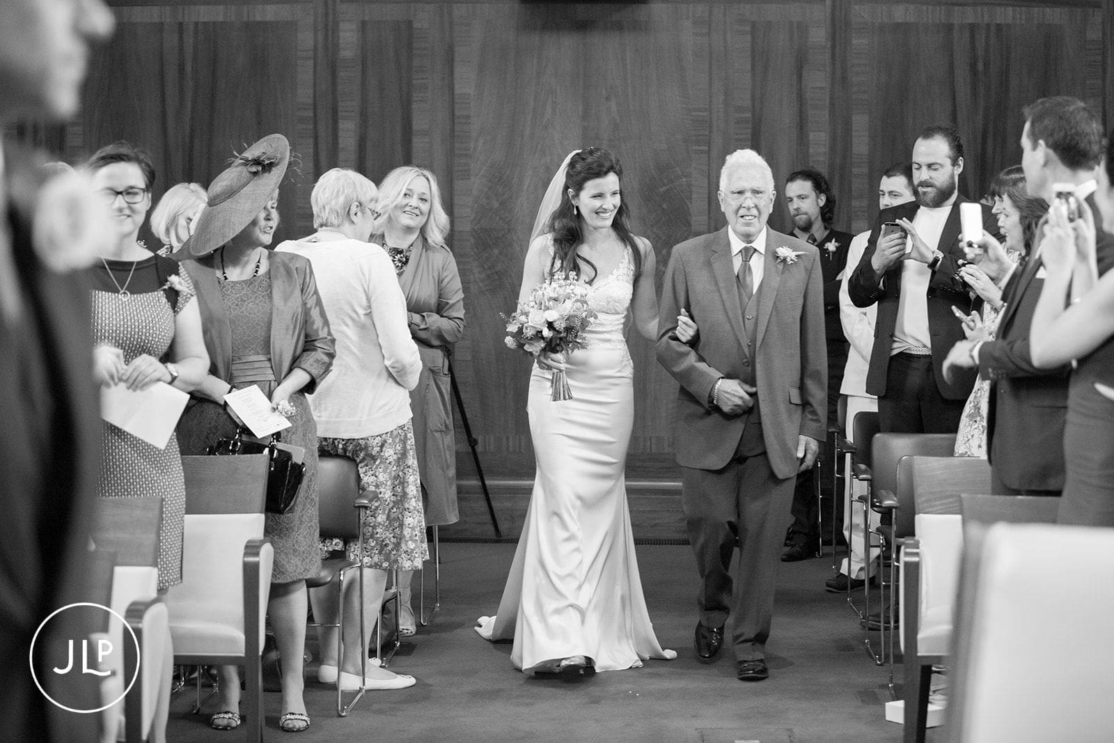 Emotional bride walking down the aisle at an Islington Town Hall wedding ceremony.
