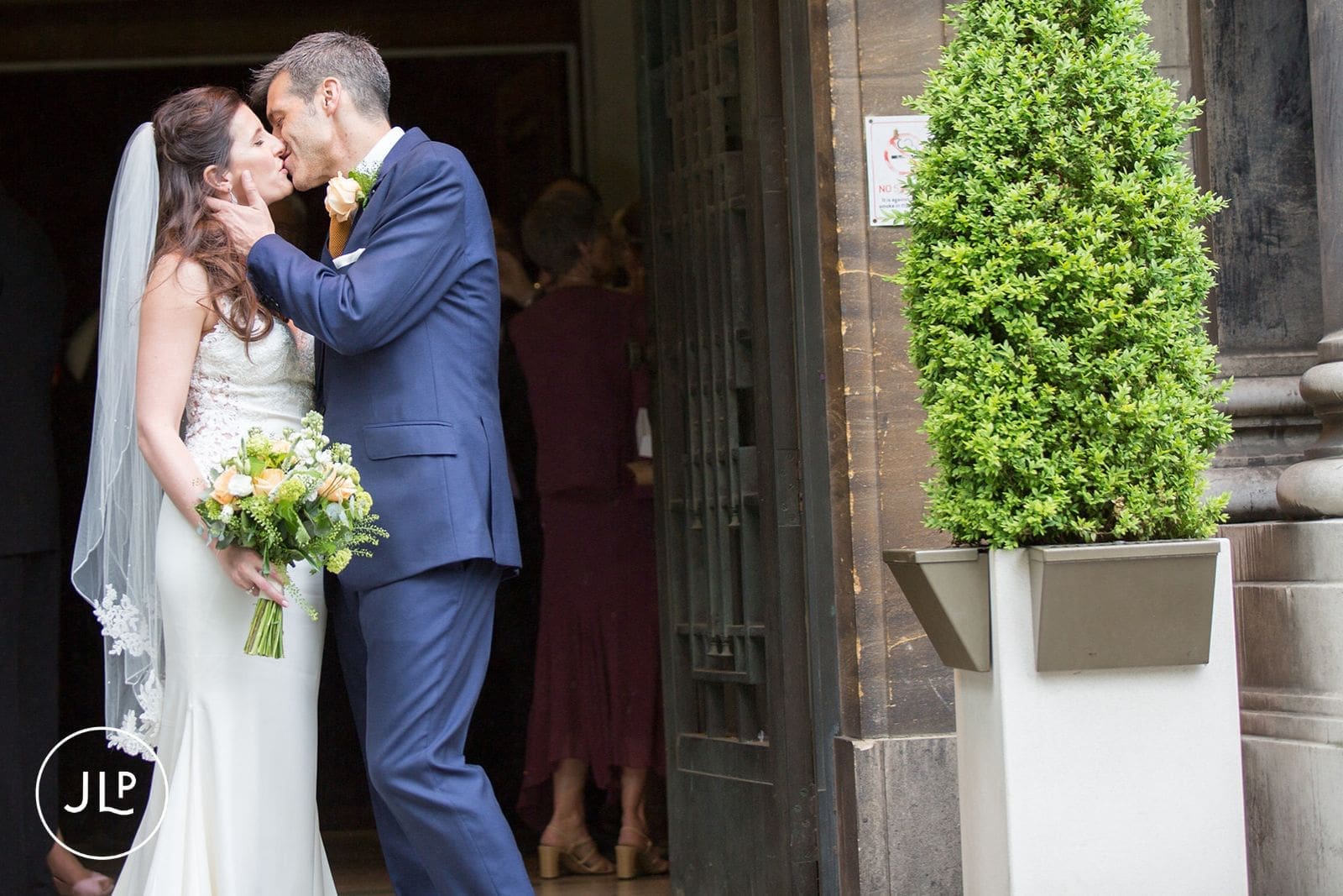 Newlyweds kissing outside the doors after their ceremony at Islington Town Hall.