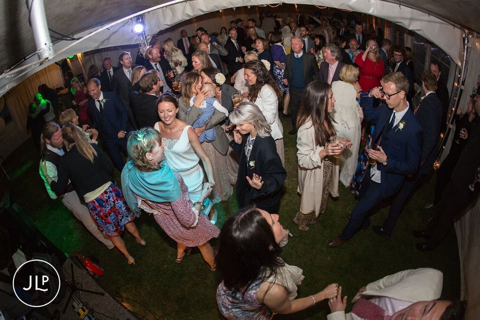 Crowded dance floor filled with guests dancing to live music at a natural Alderney wedding photography shoot.