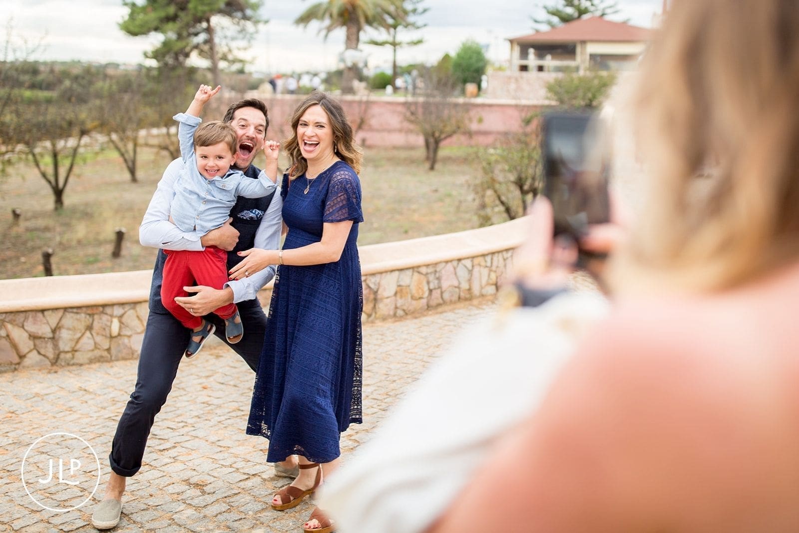 Happy wedding party guests posing for a smartphone photo at a vibrant marriage celebration.